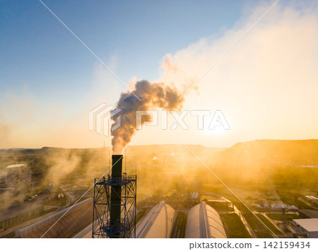 Sunrise over industrial area with smoke rising from factory stacks Sunrise over industrial area with smoke rising from factory stacks 142159434