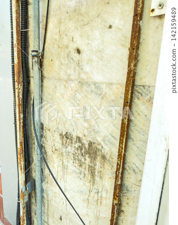 Rusty metal and marble wall with wires at a construction site during daytime Rusty metal and marble wall with wires at a construction site during daytime 142159489