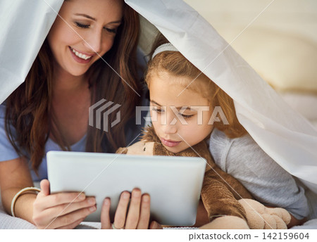 Blanket, tablet and mother with child on bed at home watch online video on app, internet or social media. Smile, love and mom with girl streaming movie, film or show on digital technology in bedroom Blanket, tablet and mother with child on bed at home watch online video on app, internet or social media. Smile, love and mom with girl streaming movie, film or show on digital technology in bedroom 142159604