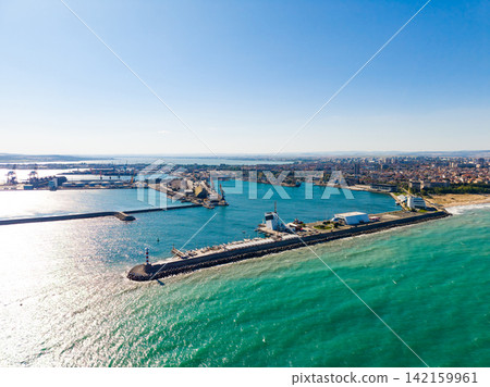 Clear view of a busy port and harbor with ships and water during a sunny day Clear view of a busy port and harbor with ships and water during a sunny day 142159961