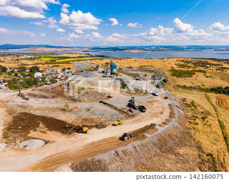 Granite quarry operation in open land with machinery working during a sunny day Granite quarry operation in open land with machinery working during a sunny day 142160075
