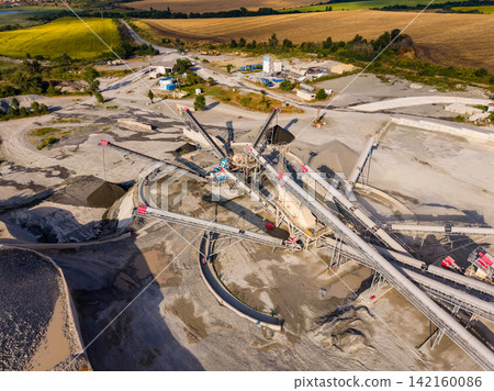 Granite quarry with machines and conveyor belts operating in a rural area during the day 142160086