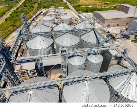 Grain storage facility with silos and machinery in agricultural area Grain storage facility with silos and machinery in agricultural area 142160262