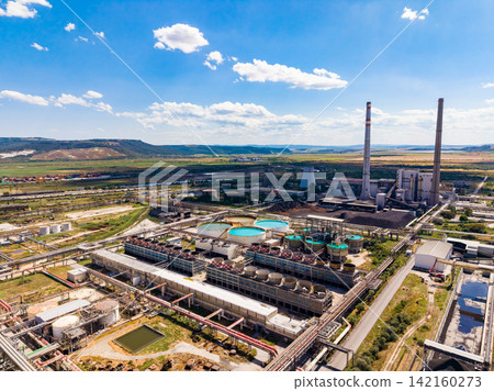 Industrial facility located near a river with large equipment and structures during daytime 142160273