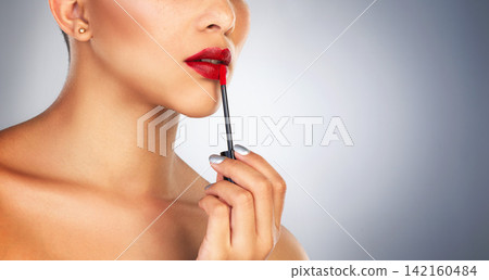Lip brush, makeup and person in studio, red lipstick and beauty for cosmetics, glow and shine of aesthetic. Self love, color and foundation on face, application and product for model in banner 142160484