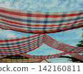 Colorful pha khao ma fabrics used as sunshade awning in a cultural festival. 142160811