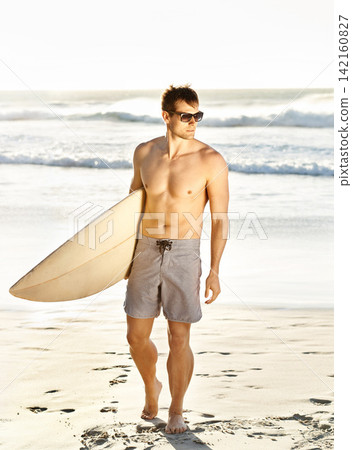 Man, surfer and sunglasses in summer at beach for holiday, exercise and wellness for fitness motivation. Athlete, workout and training in ocean for balance, strength and walking on sand for vacation. Man, surfer and sunglasses in summer at beach for holiday, exercise and wellness for fitness motivation. Athlete, workout and training in ocean for balance, strength and walking on sand for vacation. 142160827