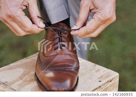 Man, groom and tie laces at outdoor wedding, fashion and formal or elegant style for marriage celebration. Male person, getting ready and preparation for event, party and hands in nature for clothes Man, groom and tie laces at outdoor wedding, fashion and formal or elegant style for marriage celebration. Male person, getting ready and preparation for event, party and hands in nature for clothes 142160935