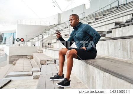 Fitness, phone and man thinking on stadium steps for training break, pause or social media scroll. Arena, stairs and runner with smartphone search, streaming or app for planning marathon workout Fitness, phone and man thinking on stadium steps for training break, pause or social media scroll. Arena, stairs and runner with smartphone search, streaming or app for planning marathon workout 142160954