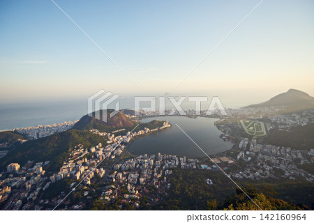 City, ocean and blue sky with vacation, drone and Rio De Janeiro for summer holiday, urban town and aerial view. Landscape, location and beach with buildings, getaway trip and mountains with sunshine City, ocean and blue sky with vacation, drone and Rio De Janeiro for summer holiday, urban town and aerial view. Landscape, location and beach with buildings, getaway trip and mountains with sunshine 142160964