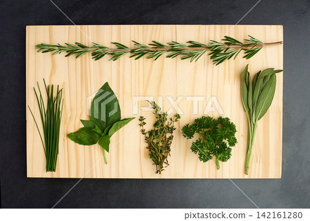 Parsley, thyme, and rosemary on chopping block for nutrition, health and adding flavour to food. Green herbs, basil and vegetables on kitchen cutting board for cooking, eating and vegan diet Parsley, thyme, and rosemary on chopping block for nutrition, health and adding flavour to food. Green herbs, basil and vegetables on kitchen cutting board for cooking, eating and vegan diet 142161280
