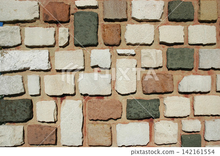 Rustic ashlar stone wall texture with mixed organic colors 142161554