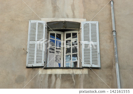 Old vintage window with white wooden shutters Old vintage window with white wooden shutters 142161555