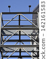 Industrial Steel Structure with Floodlights Against Blue Sky 142161583