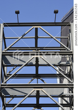Industrial Steel Structure with Floodlights Against Blue Sky 142161583