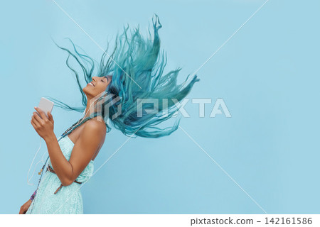 Girl, earphones and hair moving while dancing, phone and online for streaming audio on blue background. Female person, mockup space and energy in studio, kpop and app for song and music for freedom Girl, earphones and hair moving while dancing, phone and online for streaming audio on blue background. Female person, mockup space and energy in studio, kpop and app for song and music for freedom 142161586