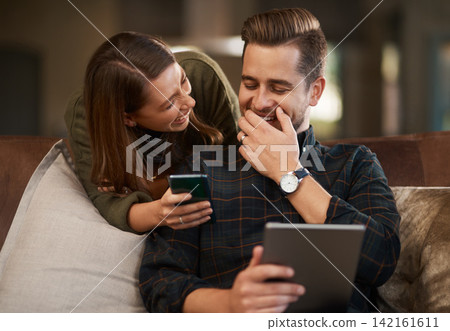 Happy couple, laugh and sofa with tablet and cellphone for streaming video, social media and online apps for relationship in home. Man, woman and tech in house on internet, affection or loving indoor Happy couple, laugh and sofa with tablet and cellphone for streaming video, social media and online apps for relationship in home. Man, woman and tech in house on internet, affection or loving indoor 142161611