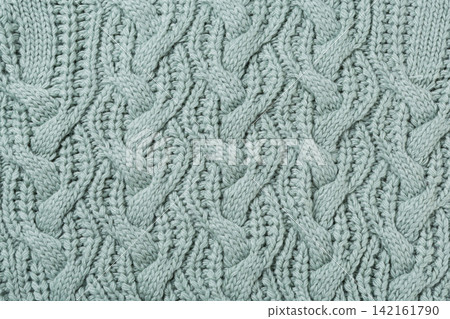 Mint green cable knit wool fabric background. Mint knitted sweater texture full frame flat lay Mint green cable knit wool fabric background. Mint knitted sweater texture full frame flat lay 142161790