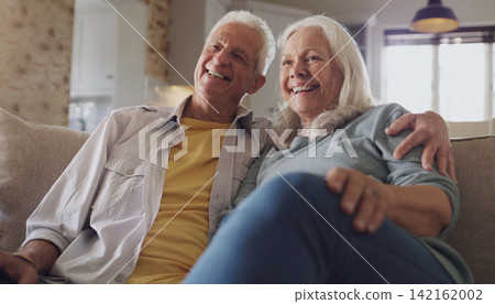 Happy, senior couple and watching tv in living room, home and house on sofa in retirement together. Partners, elderly people and relax with smile on couch for comedy, live streaming and funny video 142162002