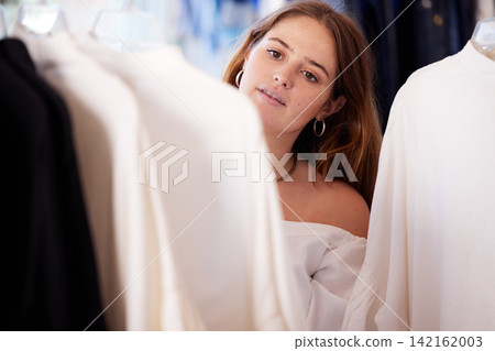 Fashion, retail and woman in store, choice and fabric quality with shopping, luxury or discount deal. Girl, consumer or customer with clothes budget, decide or person in boutique for wardrobe or sale 142162003