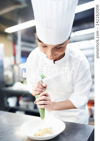 Chef, dessert and plating with professional kitchen, cooking and hospitality industry employee. Woman, catering and nutrition service for fine dining, cuisine and expert gourmet for lunch or dinner 142162006