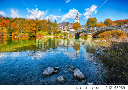 Remarkable view of Church of St. John the Baptist on Bohinj Lake . Remarkable view of Church of St. John the Baptist on Bohinj Lake . 142162089