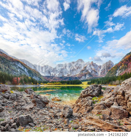 Stunning view of Fusine lake with Mangart peak on background. Stunning view of Fusine lake with Mangart peak on background. 142162107