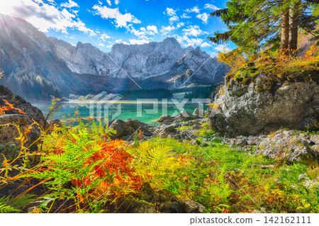 Stunning view of Fusine lake with Mangart peak on background. Stunning view of Fusine lake with Mangart peak on background. 142162111