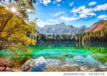 Stunning view of Fusine lake with Mangart peak on background. Stunning view of Fusine lake with Mangart peak on background. 142162119