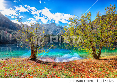 Stunning view of Fusine lake with Mangart peak on background. Stunning view of Fusine lake with Mangart peak on background. 142162120