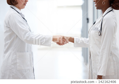 Female doctor and nurse, shaking hands for partnership, agreement and thank you for assistance. Happy, healthcare workers and handshake for teamwork, trust and support together in hospital or lab Female doctor and nurse, shaking hands for partnership, agreement and thank you for assistance. Happy, healthcare workers and handshake for teamwork, trust and support together in hospital or lab 142162406