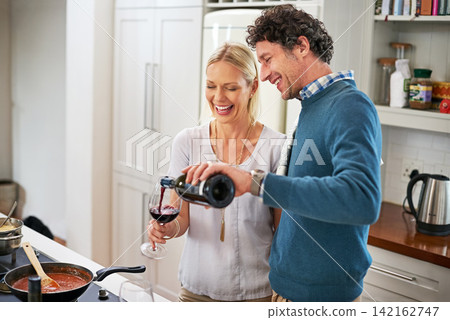 Couple, stove and pour wine for drinking in home, love and care for food or meal in kitchen. Happy people, alcohol and pan for cooking sauce and laugh for bonding, nutrition and support in marriage Couple, stove and pour wine for drinking in home, love and care for food or meal in kitchen. Happy people, alcohol and pan for cooking sauce and laugh for bonding, nutrition and support in marriage 142162747