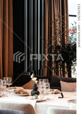 Elegant restaurant interior with table setting and modern luxury dining atmosphere Elegant restaurant interior with table setting and modern luxury dining atmosphere 142162921