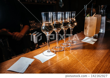 Whisky tasting glasses on bar counter with cocktails in luxury lounge atmosphere Whisky tasting glasses on bar counter with cocktails in luxury lounge atmosphere 142162927