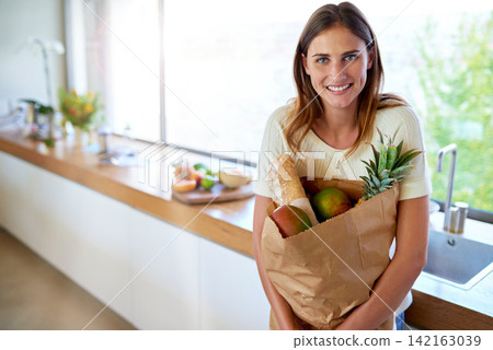 Groceries, paper bag and portrait of woman in kitchen with food, cooking or meal prep with smile. Diet, wellness and person in home with shopping, delivery and ingredients for dinner in apartment. Groceries, paper bag and portrait of woman in kitchen with food, cooking or meal prep with smile. Diet, wellness and person in home with shopping, delivery and ingredients for dinner in apartment. 142163039
