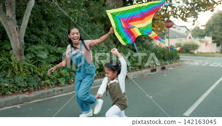Running, love or mother and daughter with kite in a road for freedom, games or fun outdoor. Flying, toy and mom with girl in a street for rainbow, celebration or support of LGBTQ, choice or lifestyle Running, love or mother and daughter with kite in a road for freedom, games or fun outdoor. Flying, toy and mom with girl in a street for rainbow, celebration or support of LGBTQ, choice or lifestyle 142163045