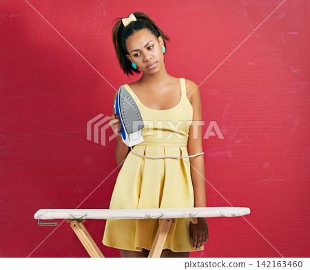 Woman, housewife and unhappy ironing in studio for laundry routine for wrinkle clothes, red background or mockup space. Female person, annoyed and home chores with maid services, cleaner or appliance Woman, housewife and unhappy ironing in studio for laundry routine for wrinkle clothes, red background or mockup space. Female person, annoyed and home chores with maid services, cleaner or appliance 142163460