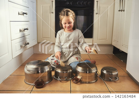 Home, instrument and child drums with music in kitchen and creativity on holiday or vacation. Kid, drummer and development of musician with noise, sound and girl playing concert on floor in house Home, instrument and child drums with music in kitchen and creativity on holiday or vacation. Kid, drummer and development of musician with noise, sound and girl playing concert on floor in house 142163484