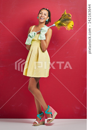 Woman, portrait and studio with feather duster for cleaning housewife on red background, hygiene or gloves. Female person, face and bacteria service as maid with mockup space, maintenance or sweep Woman, portrait and studio with feather duster for cleaning housewife on red background, hygiene or gloves. Female person, face and bacteria service as maid with mockup space, maintenance or sweep 142163644