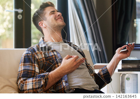 Man, earphones and phone with music for relax in home with radio, podcast or streaming audio for wellness. Person, happy and dancing in living room with track, sound and comfortable with eyes closed Man, earphones and phone with music for relax in home with radio, podcast or streaming audio for wellness. Person, happy and dancing in living room with track, sound and comfortable with eyes closed 142163645