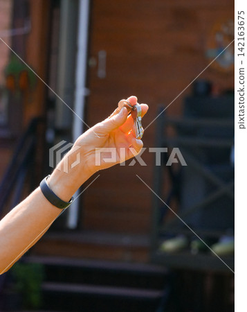 Woman holding house keys in her hand. Real estate agent handing over key to new property owner. Success, achievement and moving into new home. Residential relocation concept. Woman holding house keys in her hand. Real estate agent handing over key to new property owner. Success, achievement and moving into new home. Residential relocation concept. 142163675