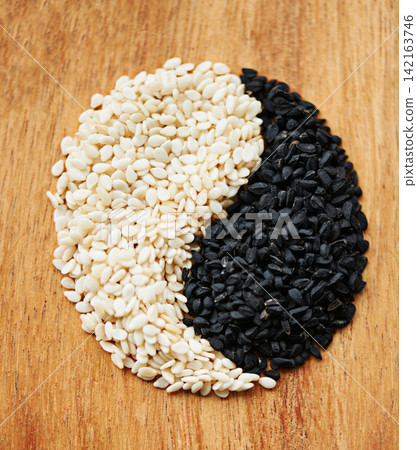 Yin yang, seeds and food with Asian symbol for balance in diet, nutrition and health with sign on wood table. Natural, ingredients and shape for wellness, spiritual tradition and different cuisine Yin yang, seeds and food with Asian symbol for balance in diet, nutrition and health with sign on wood table. Natural, ingredients and shape for wellness, spiritual tradition and different cuisine 142163746