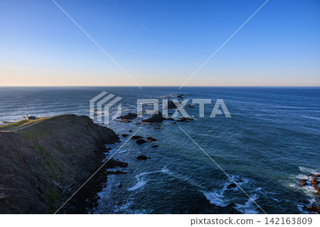 The rugged coastline of Cape Erimo in the Hidaka Mountains' Erimo-Tokachi National Park, bathed in the morning light, and the vast blue sea. The rugged coastline of Cape Erimo in the Hidaka Mountains' Erimo-Tokachi National Park, bathed in the morning light, and the vast blue sea. 142163809