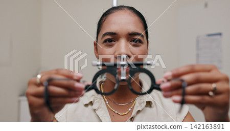Woman, optometrist and frame for eye care or equipment for examination, lens and vision testing. Closeup, tools and trial for diagnosis or eyesight with assessment, consultation and glasses with job Woman, optometrist and frame for eye care or equipment for examination, lens and vision testing. Closeup, tools and trial for diagnosis or eyesight with assessment, consultation and glasses with job 142163891