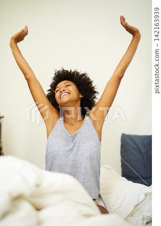 Morning, stretching and woman with smile in bed, wake up and happiness after sleeping or resting. Relax, peace and comfort of female person in bedroom for feeling fresh, calm and freedom at home Morning, stretching and woman with smile in bed, wake up and happiness after sleeping or resting. Relax, peace and comfort of female person in bedroom for feeling fresh, calm and freedom at home 142163939