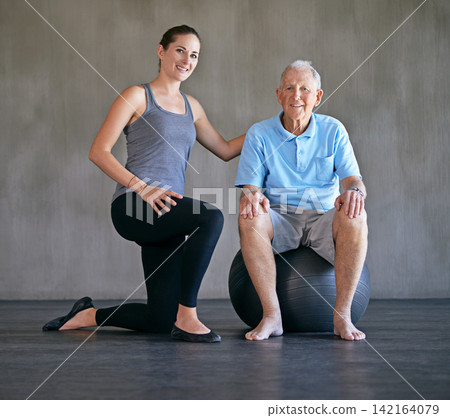 Exercise ball, happy and physiotherapist with patient for muscle injury consultation at clinic. Physical therapy, smile and portrait of healthcare worker helping senior man at rehabilitation center. Exercise ball, happy and physiotherapist with patient for muscle injury consultation at clinic. Physical therapy, smile and portrait of healthcare worker helping senior man at rehabilitation center. 142164079