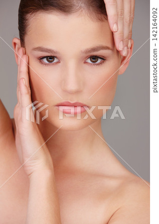 Portrait, woman and hands in studio for beauty, skincare and wellness isolated on gray background. Cosmetics, face and dermatology for wellness, facial and confidence with aesthetic and glow. Portrait, woman and hands in studio for beauty, skincare and wellness isolated on gray background. Cosmetics, face and dermatology for wellness, facial and confidence with aesthetic and glow. 142164092