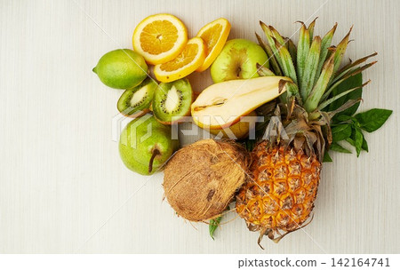 Group, tropical and fruit on table for health, smoothie and vegan diet by light background with coconut. Pear, kiwi and vitamin c with nutrition on wood surface for weight loss, milkshake and energy Group, tropical and fruit on table for health, smoothie and vegan diet by light background with coconut. Pear, kiwi and vitamin c with nutrition on wood surface for weight loss, milkshake and energy 142164741