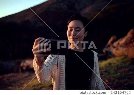 Hiking, selfie and Asian woman on mountain with smile, nature and relax on holiday adventure. Digital photography, outdoor trekking and happy girl with natural view, travel and memory on vacation. Hiking, selfie and Asian woman on mountain with smile, nature and relax on holiday adventure. Digital photography, outdoor trekking and happy girl with natural view, travel and memory on vacation. 142164793