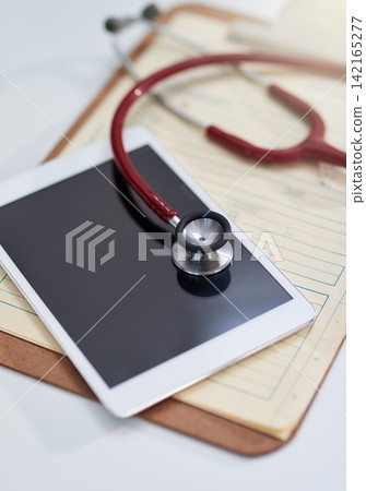 Hospital, clinic and tablet with stethoscope on desk for medical website, telehealth and research. Healthcare, cardiology and digital tech, equipment and clipboard for online consulting service Hospital, clinic and tablet with stethoscope on desk for medical website, telehealth and research. Healthcare, cardiology and digital tech, equipment and clipboard for online consulting service 142165277